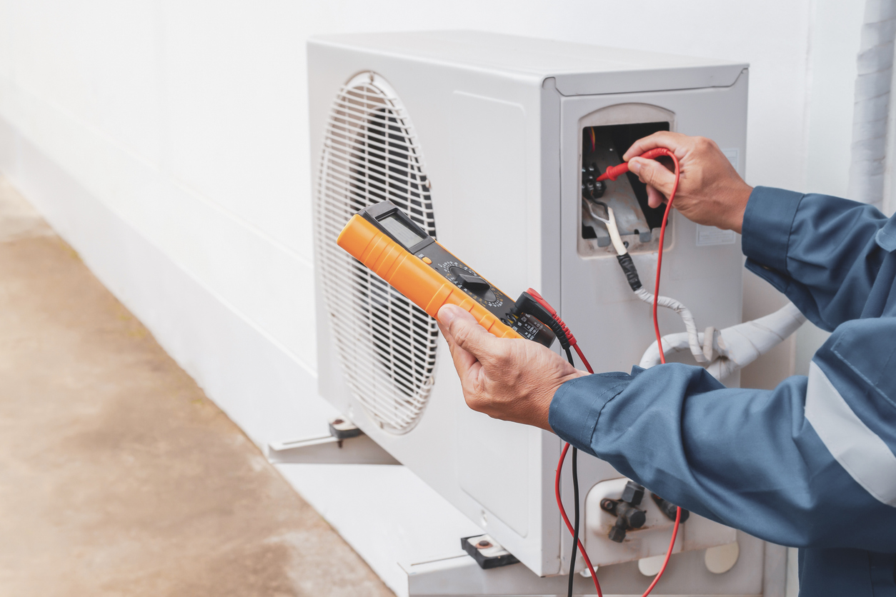 Air conditioner technician repairing central air conditioning system with outdoor tools Air conditioner technician repairing central air conditioning system with outdoor tools