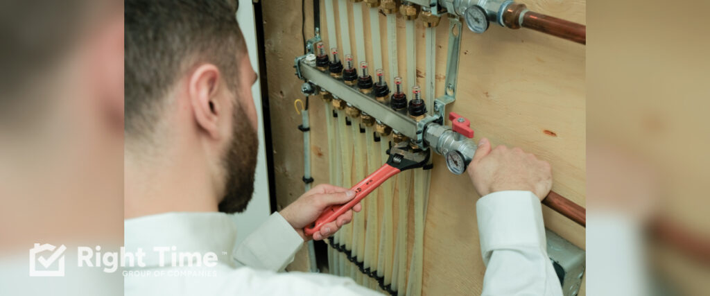 HVAC technician in Saskatoon adjusting boiler plumbing connections with wrench to fix boiler shutting off at 190 degrees issue on wooden wall mounted system